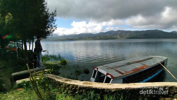 Sebuah perahu yang bersandar di dermaga danau yang tenang